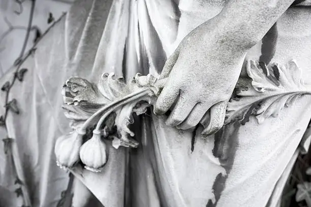 hand with flowers, close up of an old sculpture. Unknown artist of the 19th century.