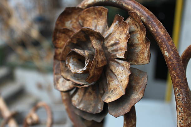 Rusted iron flower maintains it's bloom. Open to the elements like it's organic cousin, this man-made iron flower has become rusted and tarnished.