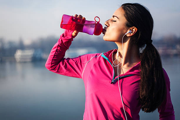 Fitness woman drinking water stock photo