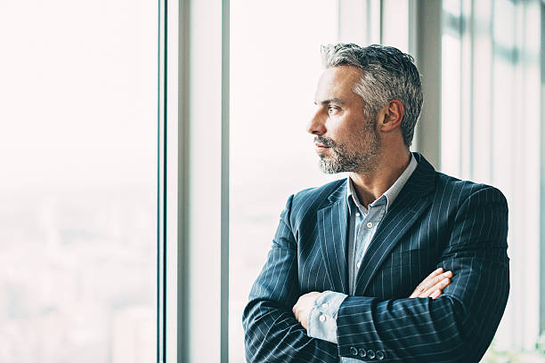 istock Mature businessman looking through the window 626437072