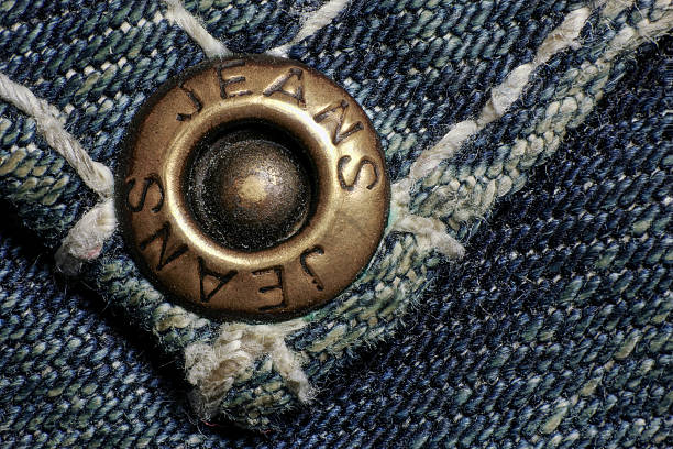 istock Copper button or rivet, old dirty jeans, macro foto. 626438540