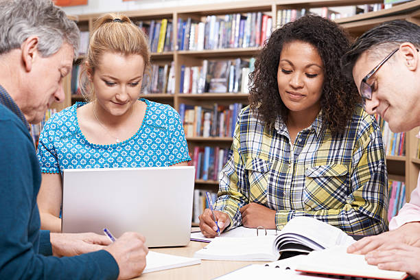 istock Group Of Mature Students Studying In Library 626439894