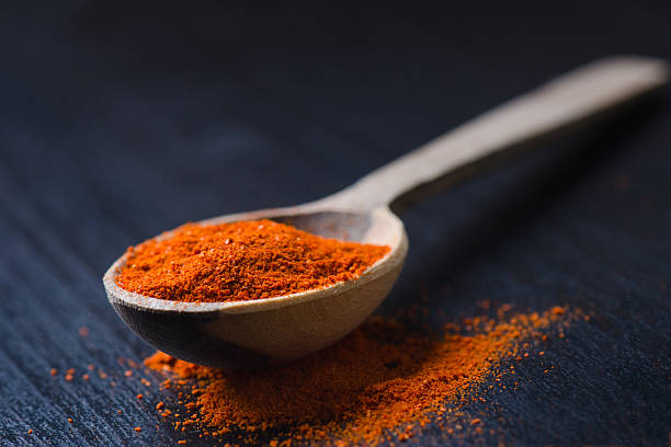 istock Red chilly peppers on a wooden spoon  with spicy. 626440004