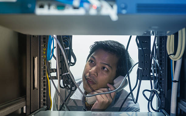 Man troubleshooting in data center with consult by telephone stock photo