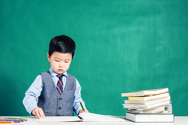 istock Little boy sitting at table and reading 626445972
