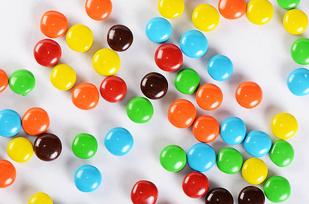 closeup of pile colorful chocolate candies - candy coated imagens e fotografias de stock