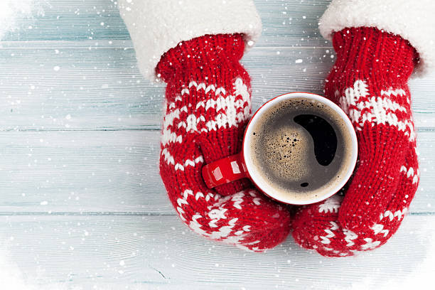 istock Female hands holding hot coffee above wooden table 626457334