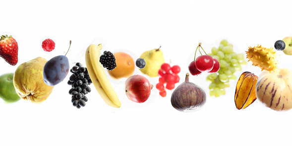 Panoramic close-up of flying or falling fruits, studio shot, selective focus for 3D look.    