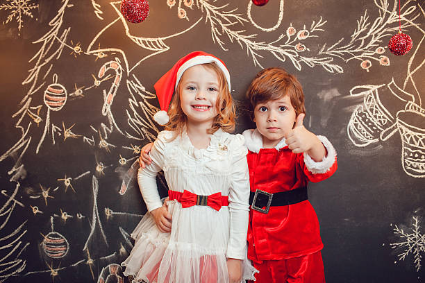 Niños Vestidos Como Santa Claus De Pie Sobre Fondo Oscuro Con Foto de stock  y más banco de imágenes de Acontecimiento - iStock