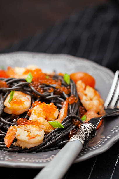 istock Black spaghetti with shrimps and red caviar 626460308