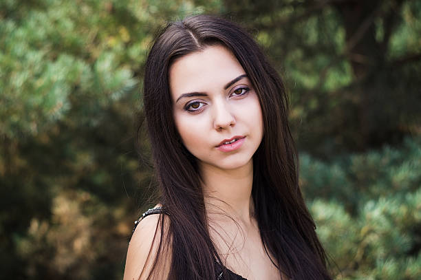 istock Graceful charming brunette model posing in black dress  coniferous park 626461004