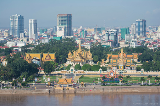 Phnom Penh Cityscape. Foreground- The Royal Palace, in Phnom Penh, Cambodia, is a complex of buildings which serves as the royal residence of the king of Cambodia. Its full name in the Khmer language is Preah Barum Reachea Veang Chaktomuk Serei Mongkol.