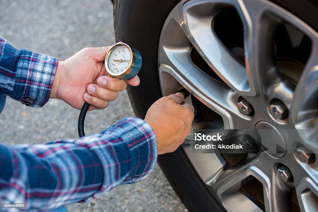 Checking Tire Pressure Checking tire pressure with pressure gauge Tire - Vehicle Part Stock Photo