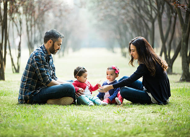 istock Latin family with babies sitting on the grass 626465382