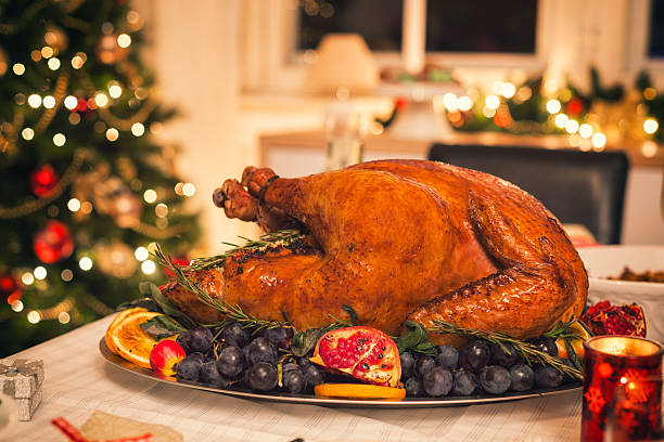 Traditional Stuffed Turkey with Side Dishes Table is set up for Holiday dinner. On the table is a traditional stuffed roasted turkey with side dishes and Christmas decoration roast turkey stock pictures, royalty-free photos & images