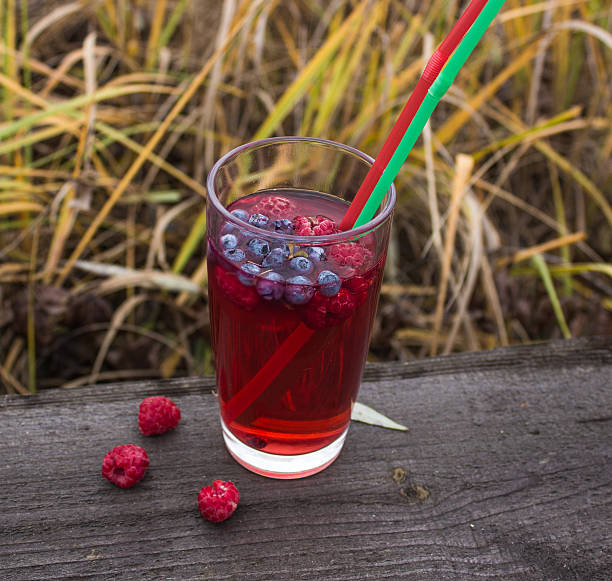 гранатовый сок с ягодами на фоне лугов - mishmash стоковые фото и изображения