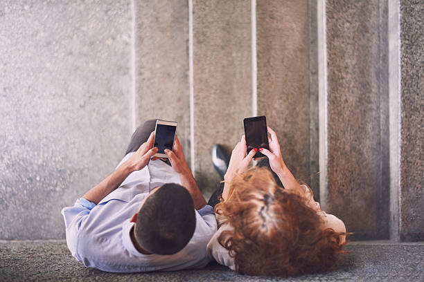 Young couple texting messages over smart phones stock photo
