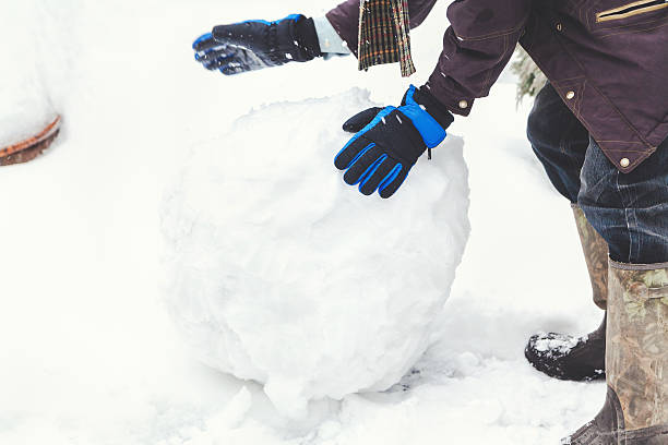 istock Hands in gloves rolled large snowball 626468120