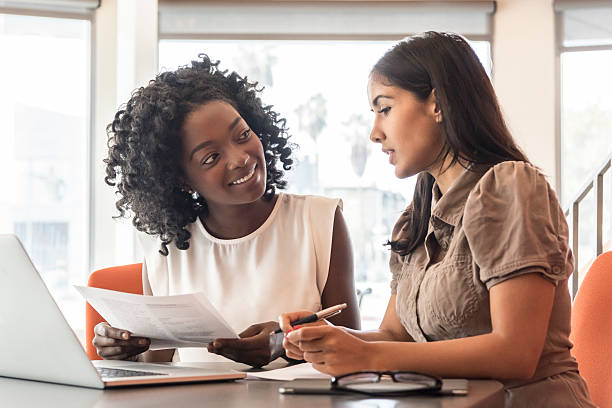 istock Two businesswomen at desk with laptop and notes 626468926