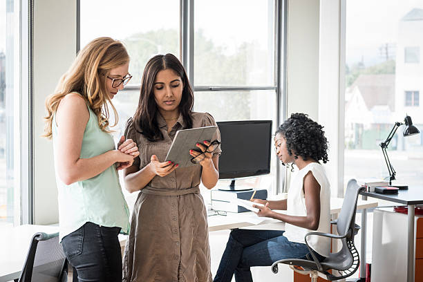 istock Two businesswomen looking at digital tablet in modern office 626469124