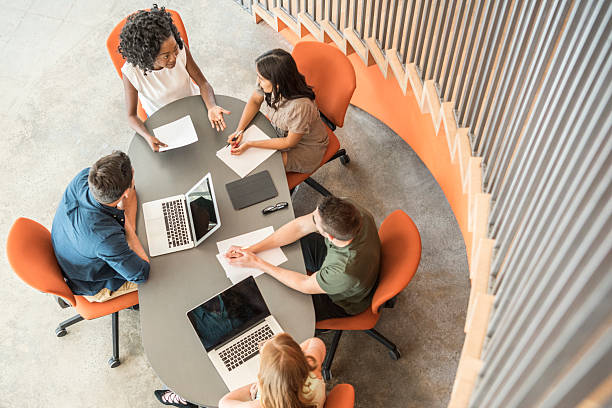 istock Five business people sitting around table discussing, high angle 626469422