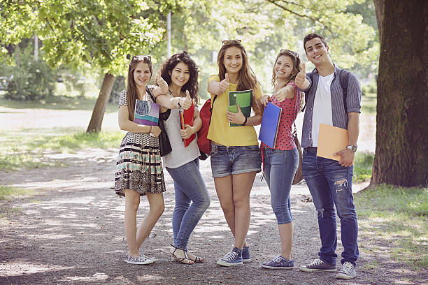 подростковая студентов с жест класс - thumbs up teenager adolescence group of people стоковые фото и изображения