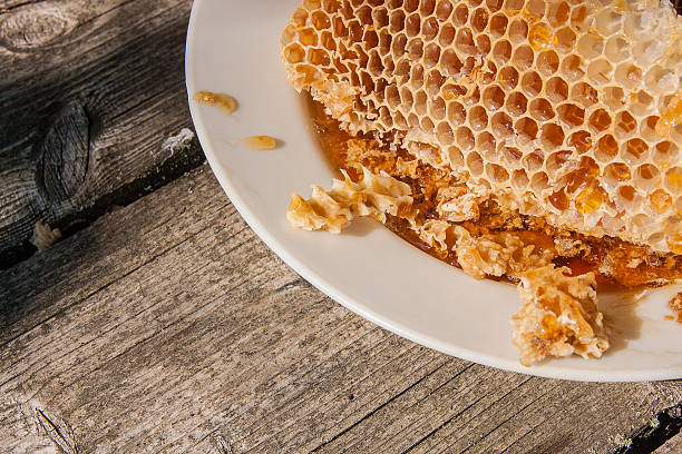 istock White plate with section of wax honeycomb from beehive 626486582