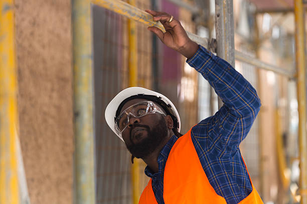 preocupado engenheiro afro-americano olhando para cima entre andaimes - hardhat equipment installing work tool - fotografias e filmes do acervo