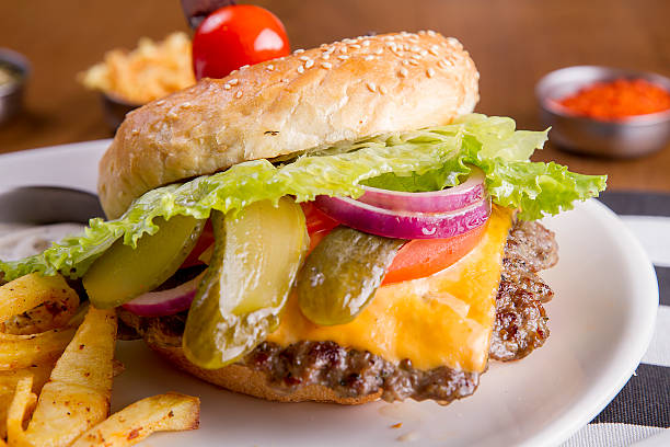 istock Hamburger pinned with knife on white plate with fresh fries 626513158