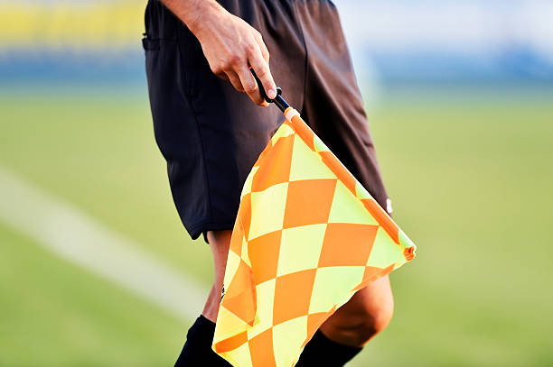 fußballschiedsrichter mit abseitsflagge - referee soccer authority linesman stock-fotos und bilder