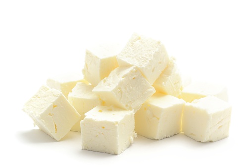 Feta cheese diced into cubes, isolated on a white background