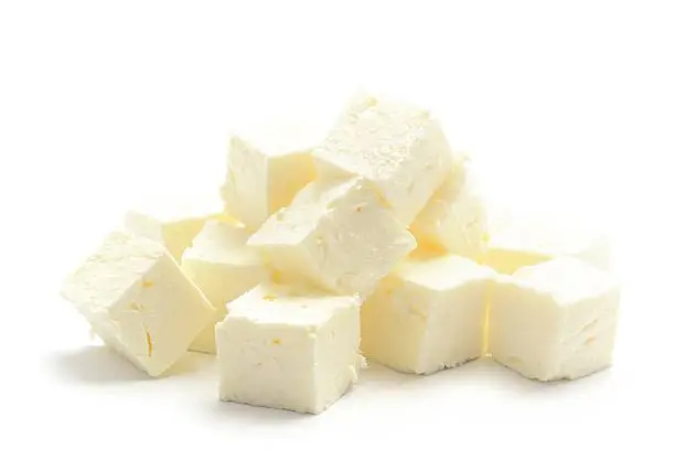 Feta cheese diced into cubes, isolated on a white background