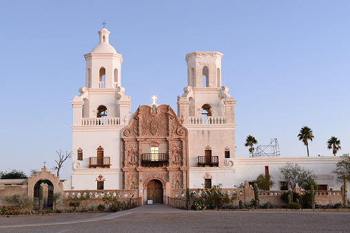 San Xavier Mission at dawn, Tucson, Arizona, USA. San Xavier Mission is a Catholic mission founded in 1692. It is a national historic landmark located 9 miles south of downtown Tucson. The mission 's interior is filled with original statues and mural paintings of 18th century. It is a popular tourist destination.