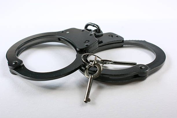 istock Black handcuffs and keys isolated on a white background 626529226