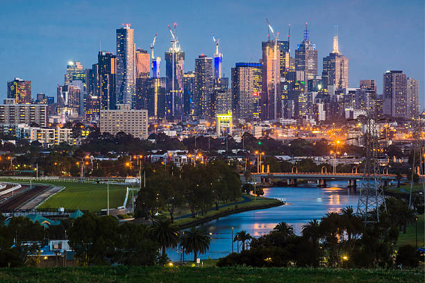 Melbourne and the Maribyrnong River Skyscrapers in the Melbourne CBD, with the Maribyrnong River before it. clear sky night sunset riverbank stock pictures, royalty-free photos & images