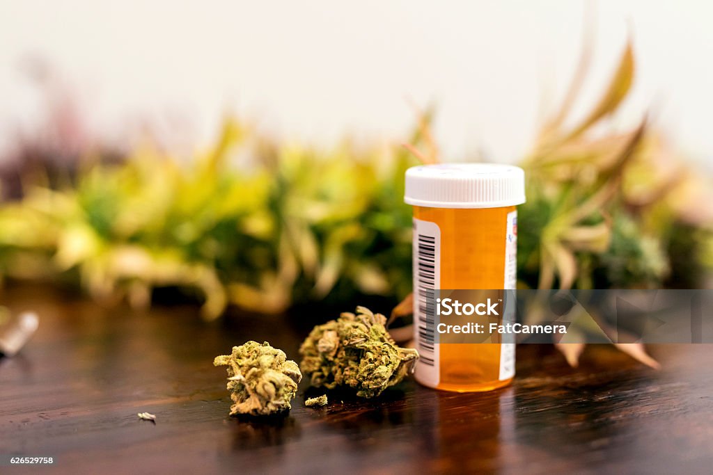 Marijuana buds sitting next to prescription medicine bottle Medical Cannabis Stock Photo