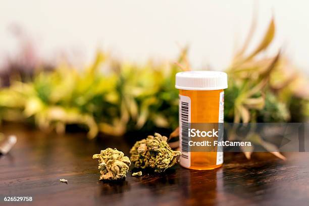 Marijuana Buds Sitting Next To Prescription Medicine Bottle Stock Photo - Download Image Now