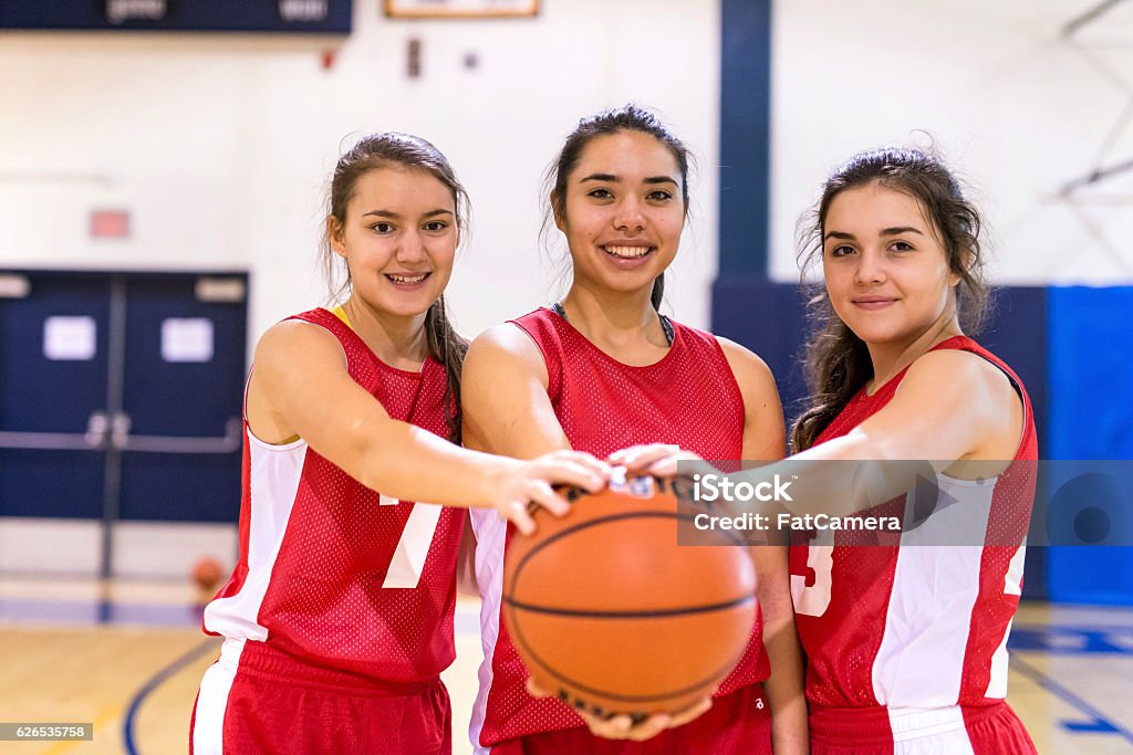 Diverse group of female basketball players holding a basketball Sport Stock Photo