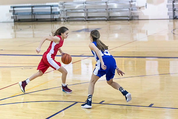 Teenage female basketball player one on one against another girl Teenage female basketball player one on one against another girl charging sports photos stock pictures, royalty-free photos & images