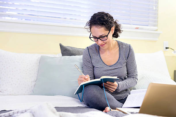 istock Hispanic adult female smiling while journaling over the weekend 626535866