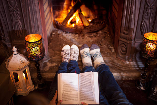 istock Couple relaxing at home reading a book. Feet in wool 626538238