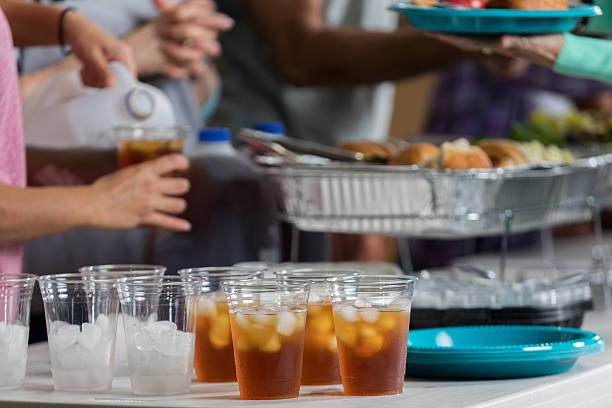 istock Unrecognizable volunteers serve people in soup kitchen 626541466