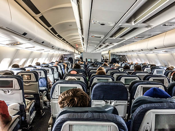 istock Passengers in a plane seen from behind above seats 626542772