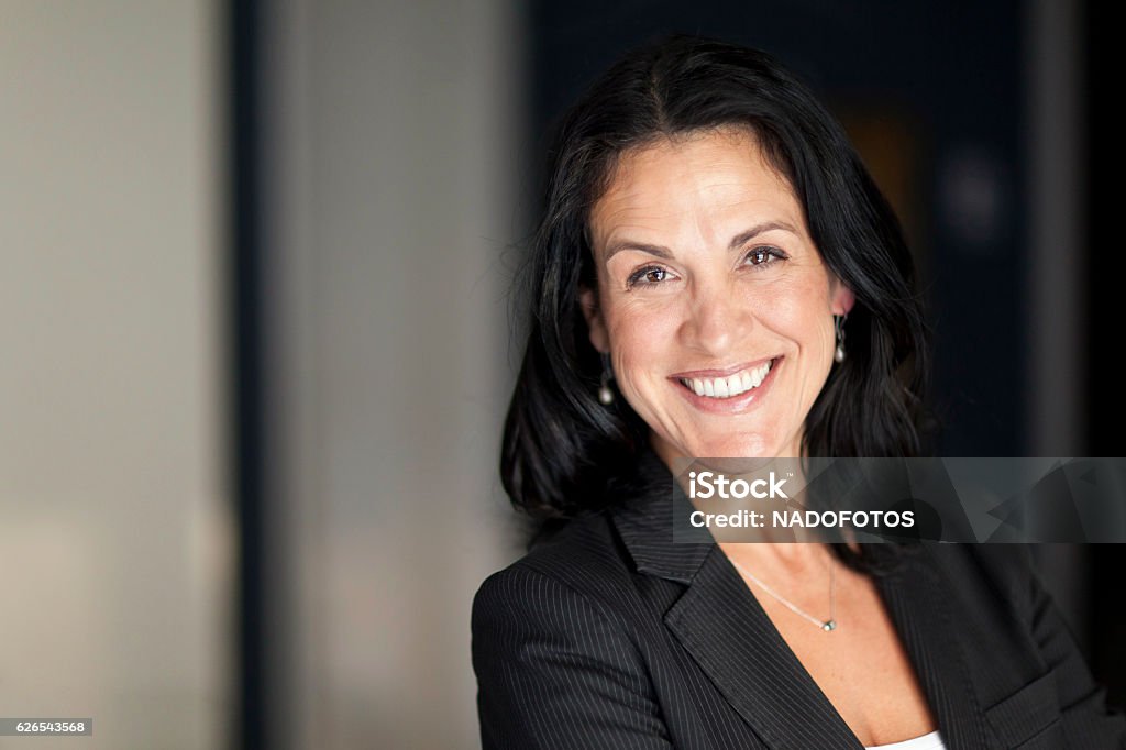 Mature Spanish Businesswoman Smiling At The Camera. At The Office. Businesswoman Stock Photo