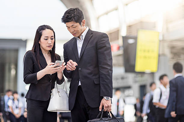 commuters using mobile phone at station - rush hour commuter on the phone tokyo prefecture imagens e fotografias de stock