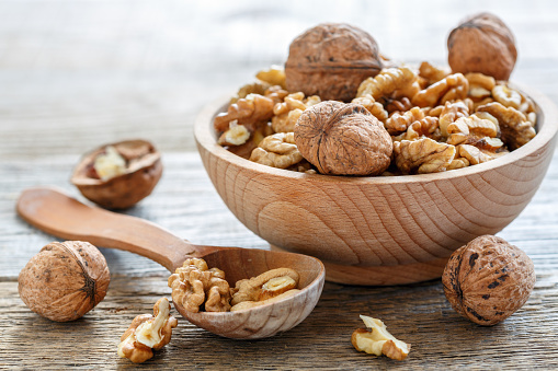 Walnuts in a bowl on old table closeup.