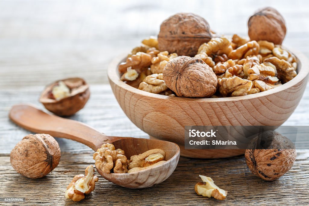Walnuts in a bowl. Walnuts in a bowl on old table closeup. Walnut Stock Photo
