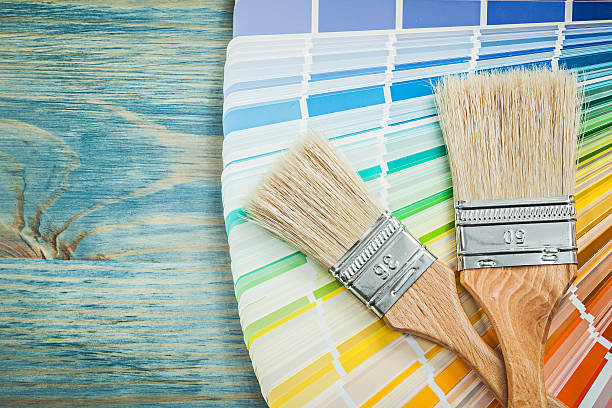 istock Multi colored color sampler paint brushes on wooden board constr 626551274