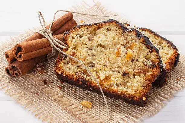 Pices of fresh baked homemade fruitcake and ingredients for baking on boards, delicious dessert