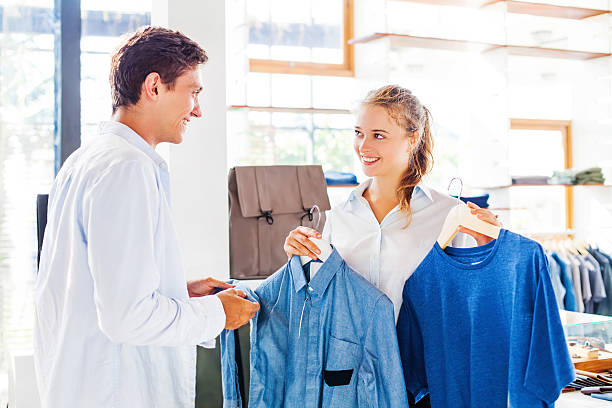 verkäuferin hilft bei der auswahl der kleidung - women choosing choice clothing stock-fotos und bilder